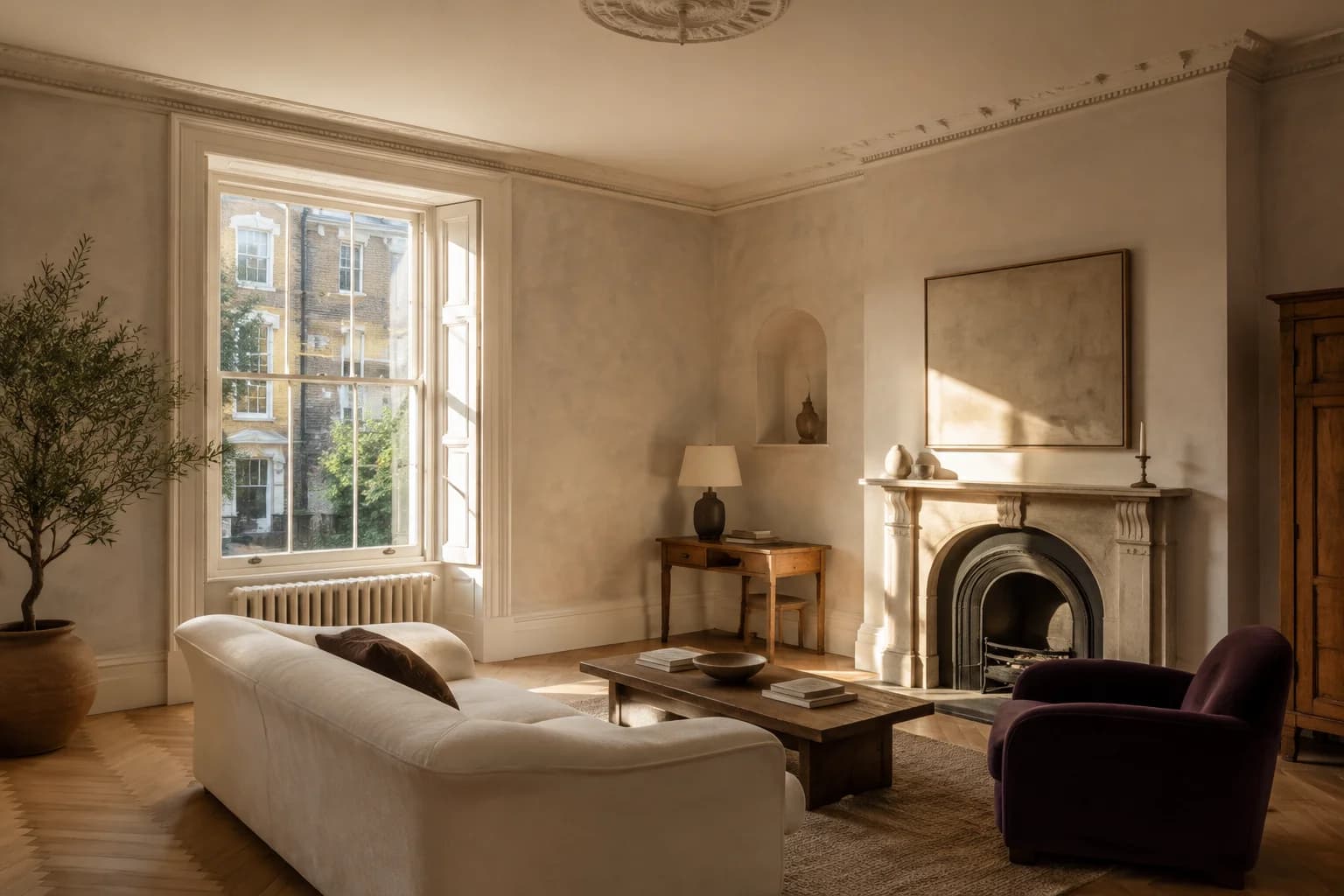 Concept period sitting room with warm plaster, original mouldings, a linen sofa and aubergine armchair